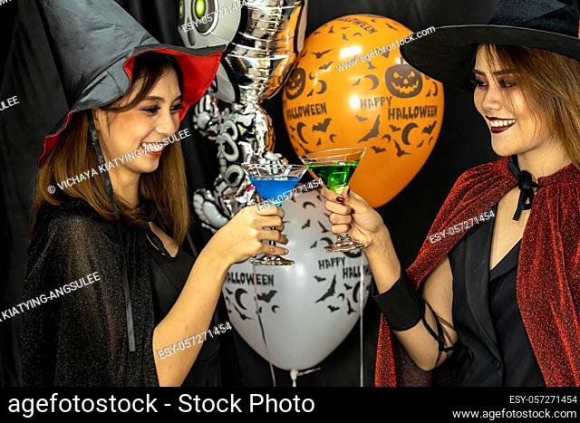 Group of young adult and teenager people celebrating a Halloween party carnival Festival in Halloween costumes drinking alcohol cocktail