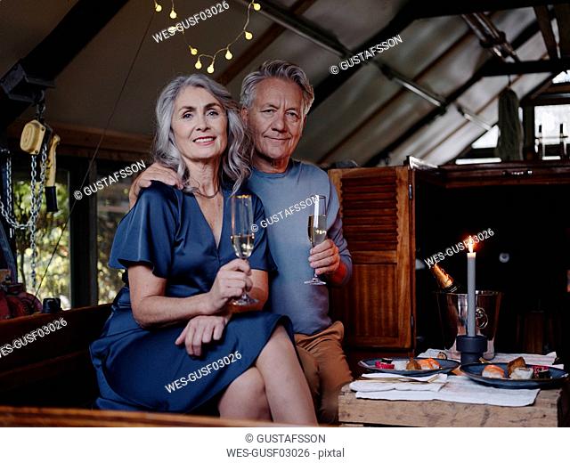 Portrait of senior couple having a candlelight dinner on a boat in boathouse