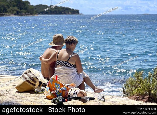 Plava Laguna, Adriatic coast near Porec / Croatia, beach. Vacationers, couple, couple on the stone beach, rocky beach. ?. - Porec/Istrien/Kroatien