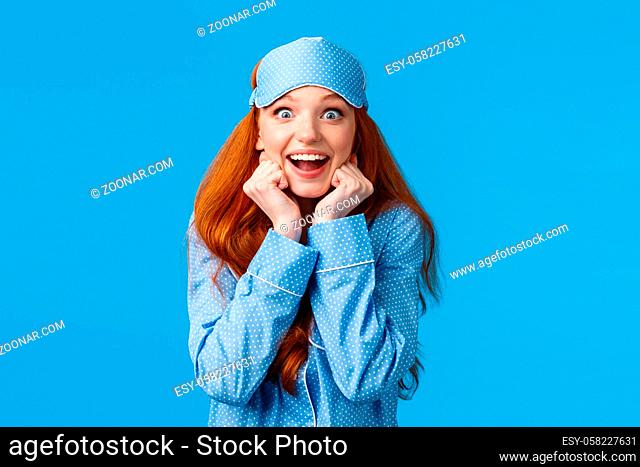 Excited and impressed, amused redhead girl listening fascinating story during sleepover friends house, wearing pyjama and sleep mask