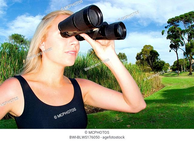 woman searching with a large pair of binoculars