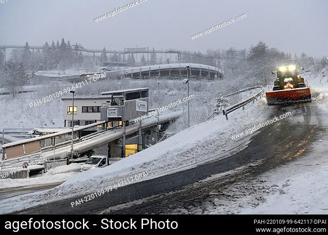 09 January 2022, North Rhine-Westphalia, Winterberg: Bobsleigh: World Cup, two-man bobsleigh, women, 1st run. A snowplow is gritting the tracks at the bobsleigh...