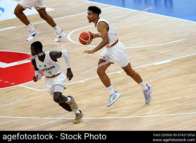 06 September 2023, Philippines, Manila: Basketball: World Cup, Germany - Latvia, knockout round, quarterfinals. Germany's Maodo Lo (r) and Dennis Schröder in...