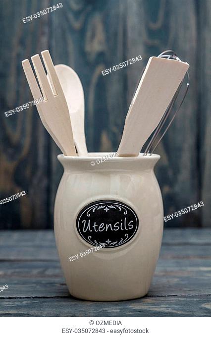 Wooden Kitchen Utensils like spoon, spatula and fork on blue wooden background