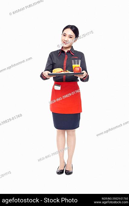 Young Waitress carrying tray with food, studio shot