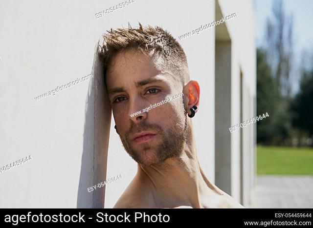 Portrait of a pretty guy dressed in boxers on a concrete wall