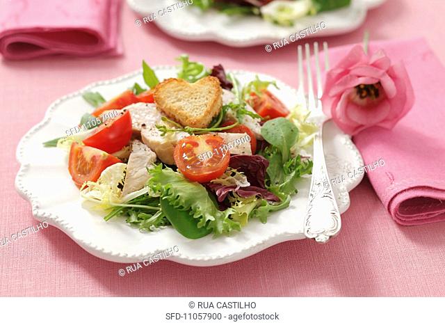Green salad with cherry tomatoes, grilled chicken breast and heart shaped croutons