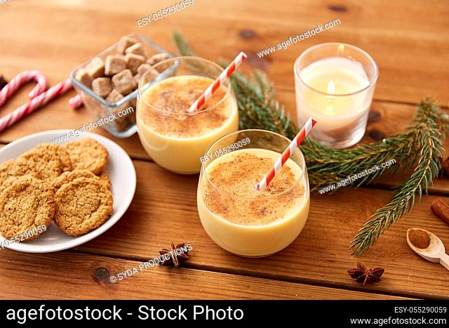 glasses of eggnog, oatmeal cookies and fir branch