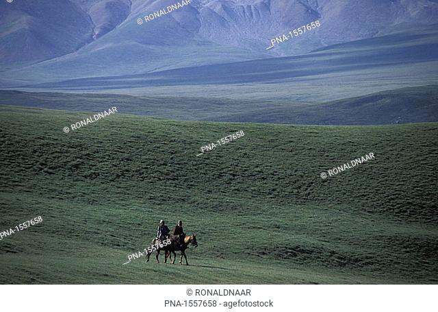 Two Kirghiz herdsmen driving their horses through the Tien Shan mountains, Kirghizistan