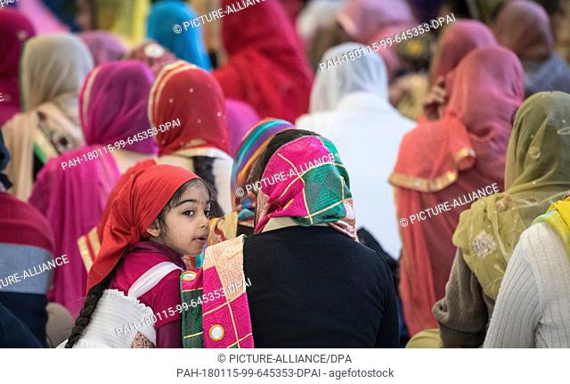 A young woman listens to the recitations of a religious text at the Gurdwara Sikh temple in Frankfurt am Main, Germany, 7 January 2018