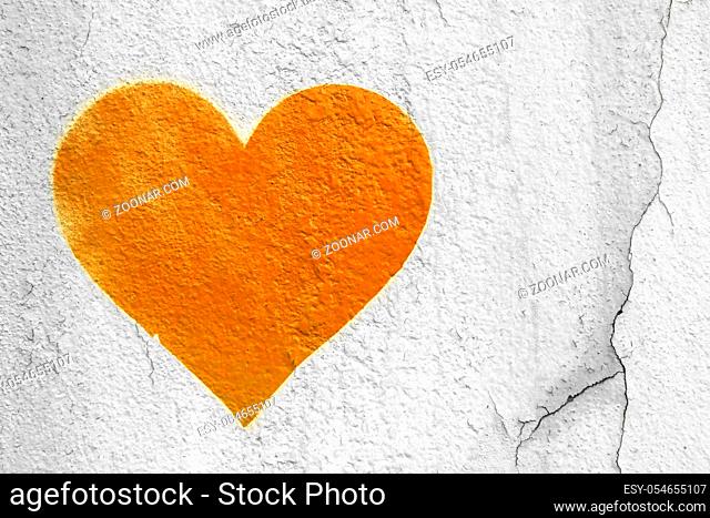 Orange love heart hand drawn on grungy wall. Textured background trendy street style