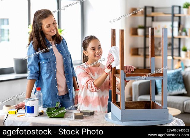 mother and daughter cleaning old table with tissue