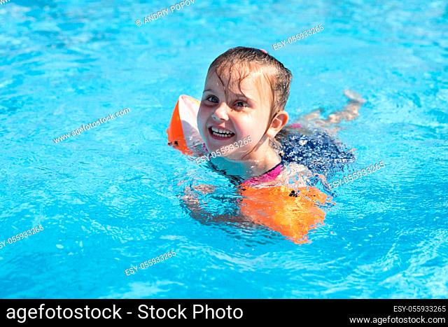 Child Girl In Swimming Pool Playing And Learning