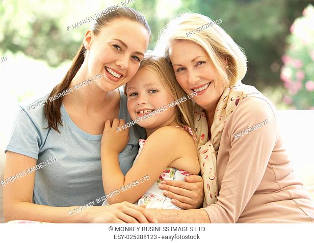 Grandmother With Daughter and Granddaughter Laughing Together On Sofa