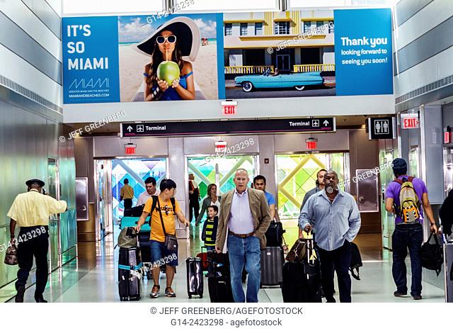 Florida, Miami, Miami International Airport, MIA, terminal, concourse, arriving passengers, Black, man, Asian, luggage