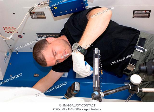 NASA astronaut Reid Wiseman, Expedition 40 flight engineer, conducts a session with the Binary Colloidal Alloy Test-C1, or BCAT-C1