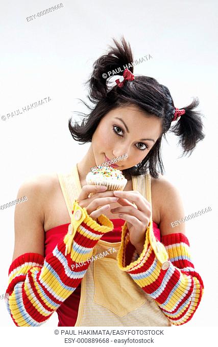 Beautiful Latina girl with huge eyes open holding a cupcake, isolated