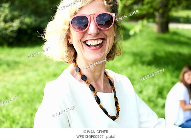 Portrait of happy senior woman wearing sunglasses in park