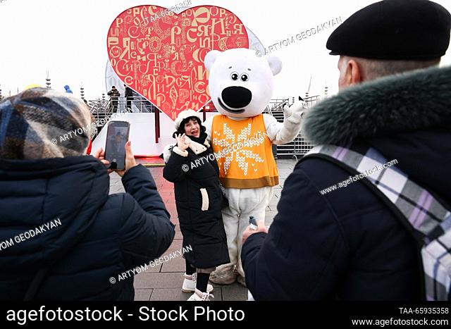 RUSSIA, MOSCOW - 20 de diciembre de 2023: Una mujer posa para una foto con un intérprete vestido como oso polar durante la exposición internacional de Rusia...