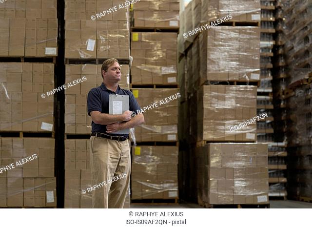 Man holding clipboard in warehouse