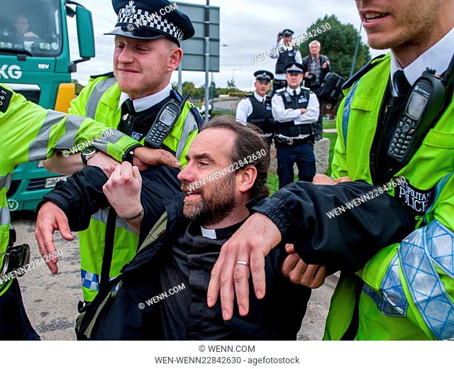 Police remove a vicar from a blockade during a protest against the DSEI, one of the world’s largest arms fairs. Activists are angered by the impact they claim...