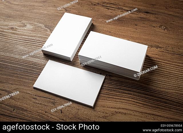 Photo of blank white business cards on wooden background. For design presentations and portfolios