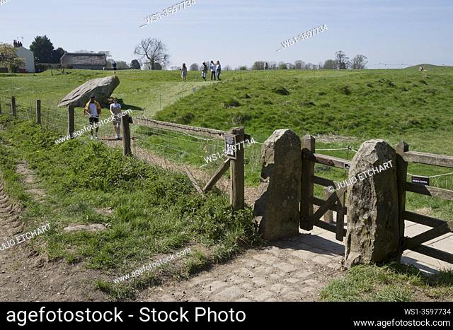Visitors to the ancient Avebury Neolithic henge monument containing three stone circles, in Wiltshire, southwest England, UK