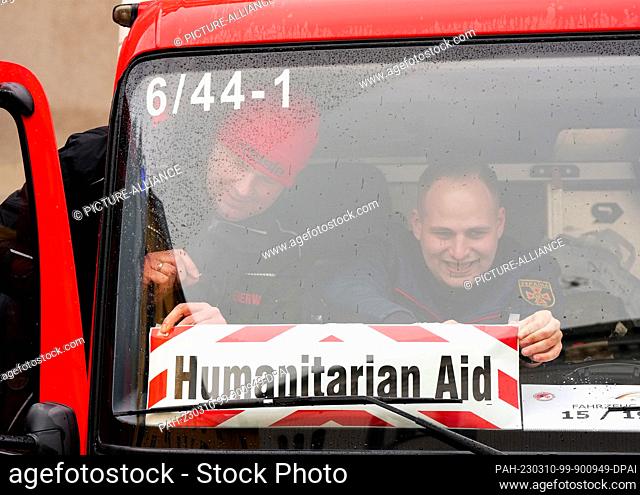 10 March 2023, Brandenburg, Potsdam: Alexander Engel (l) and Thomas Scheewe from the Wandlitz Fire Department attach a sign with the inscription ""Humanitarian...