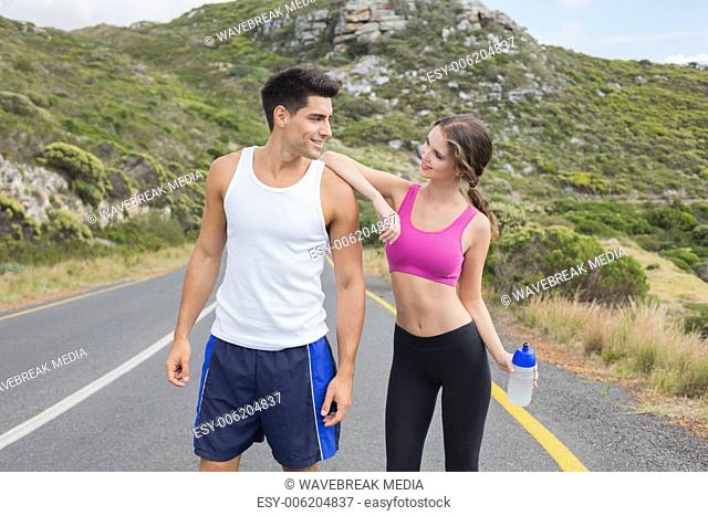 Portrait of a fit couple standing on road