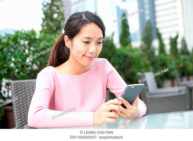 Woman use of mobile phone at outdoor coffee shop