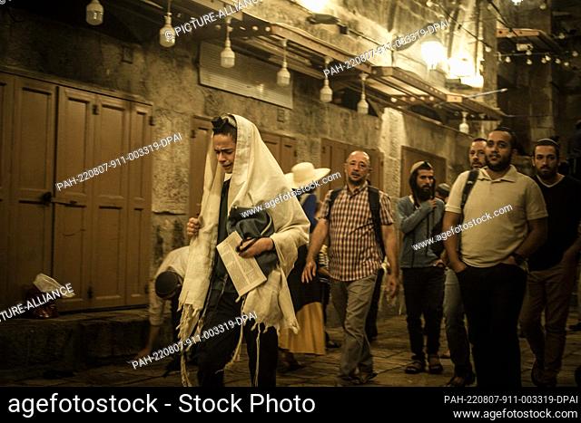 07 August 2022, Israel, Jerusalem: Jews pray near the door of the Al-Aqsa Mosque compound in the old city of Jerusalem during the holy day Tisha B'Av