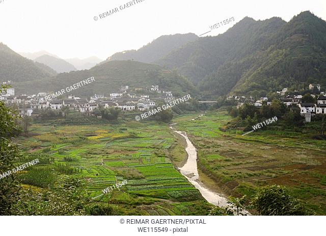 Mountains and farms of Qiashe Xiang village on flood plain of Fengle river Huangshan China