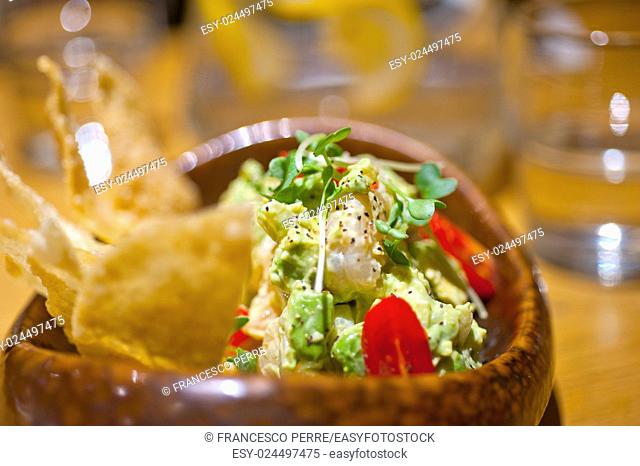 fresh avocado and shrimps salad with nachos on side