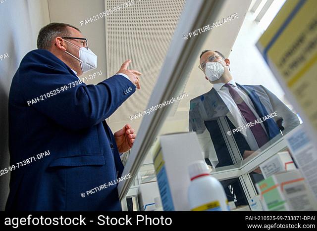 25 May 2021, Saxony-Anhalt, Bernburg: Jan Lukowczyk (l), CEO of the serum plant, shows Jens Spahn (r, CDU), Federal Minister of Health