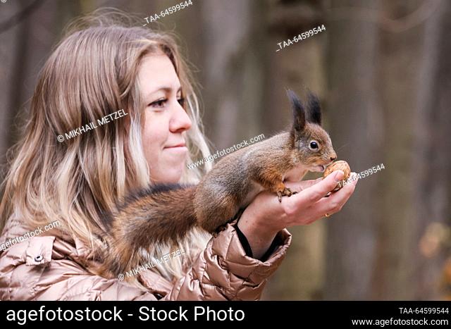 RUSSIA, MOSCOW - NOVEMBER 9, 2023: A woman poses with a squirrel in Tsaritsyno Park in autumn. Mikhail Metzel/TASS