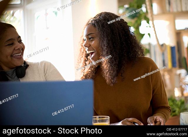 Feliz madre e hija usando laptop
