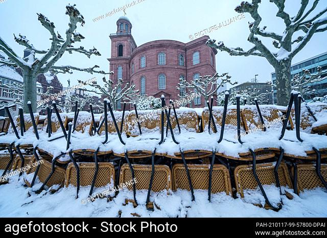 17 January 2021, Hessen, Frankfurt/Main: In front of the background of the Paulskirche, chairs and tables of a café are stacked