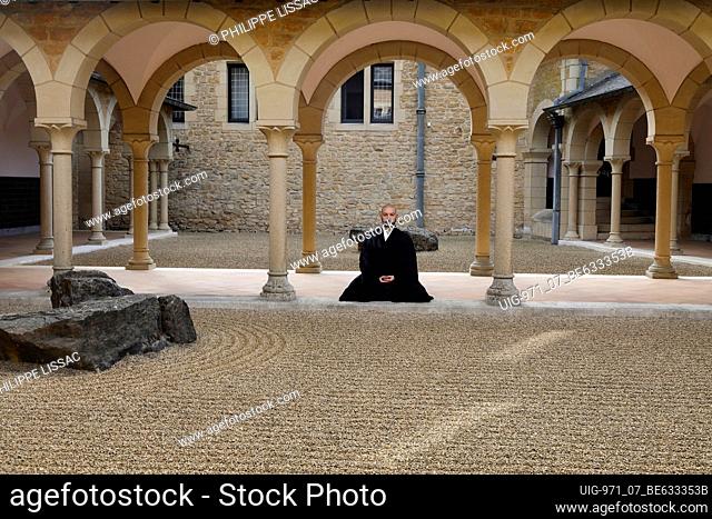 Zen buddhist monk practising zazen (meditation) in Orval trappist abbey's zen garden, Belgium