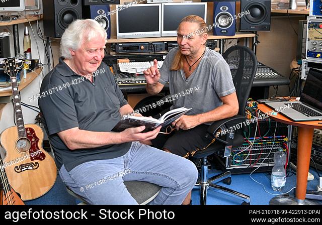 16 July 2021, Brandenburg, Hoppegarten: Music expert Wolfgang Martin (l) and Silly guitarist Uwe Hassbecker discuss the new book ""Paradiesvögel fängt man nicht...