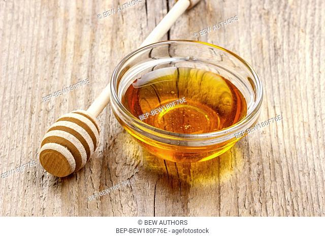 Bowl of honey on wooden table. Symbol of healthy living and natural medicine. Aromatic and tasty