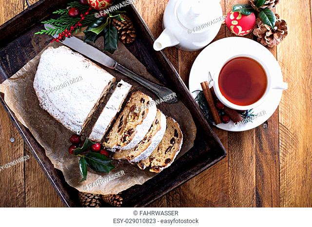 Christmas stollen with dried fruits and marzipan served with tea and decorations
