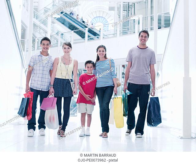 Family carrying shopping bags in mall