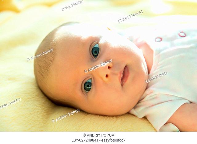 Portrait Of An Adorable Innocent Child Relaxing On Yellow Blanket