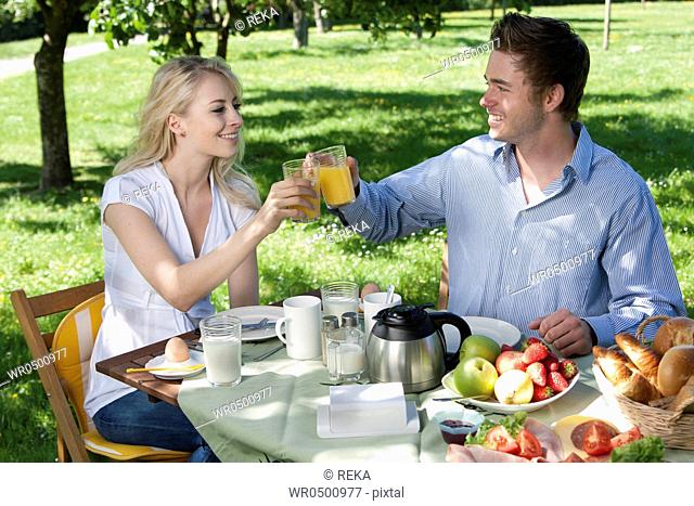 Young couple having breakfast in park