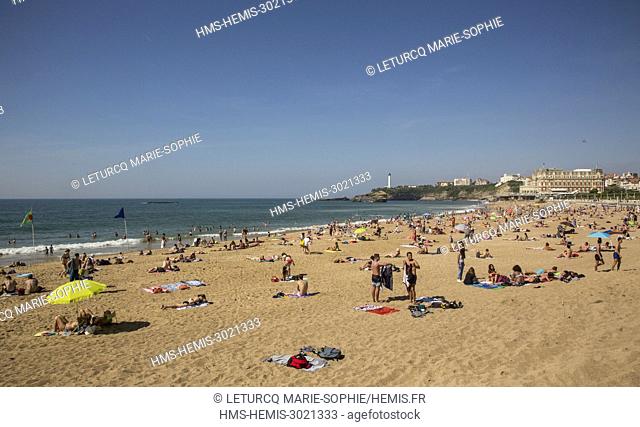 France, Pyrennees Atlantique, Basque Country, Biarritz, tourist and bathers on the Grande Plage with the Hotel du Palais in the background