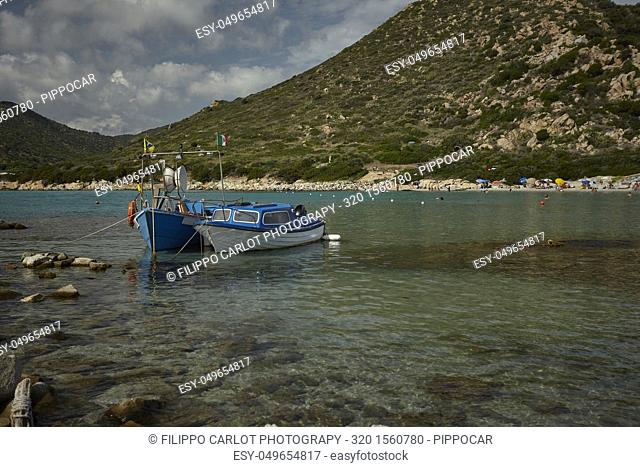 Couple of very small fishing boats moored at the seashore in a beautiful Sardinian beach: Punta Molentis
