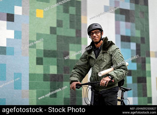 Smiling bicycle courier looking at camera