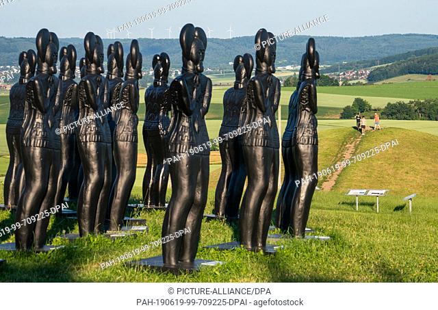 17 June 2019, Hessen, Glauburg: Plastic replicas of the Celtic prince of the artist Ottmar Hörl stand in front of the Museum Keltenwelt am Glauberg