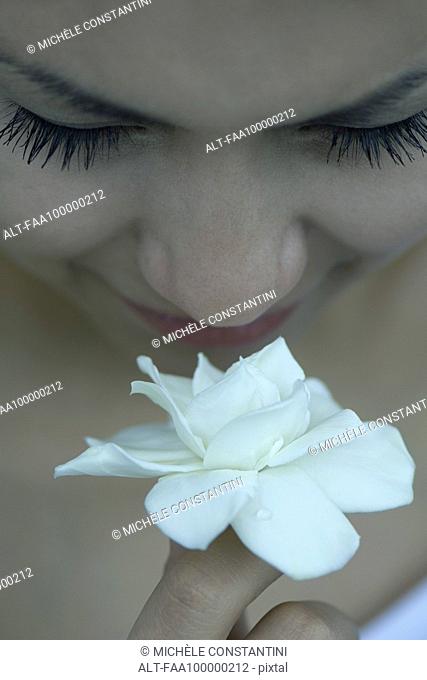 Young woman smelling gardenia, close-up