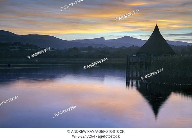 The Crannog at Llangorse Lake in the Brecon Beacons National Park captured at sunset with Pen y fan in the distance. The image was captured from a nearby jetty...
